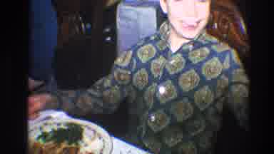 Toledo Ohio (1968): Boy Wearing Green Shirt Waves To Camera While Sitting In Brown