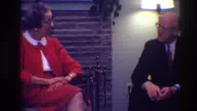 Toledo Ohio (1968): Woman Wearing Red Suit Talks To Man Wearing Black Suit