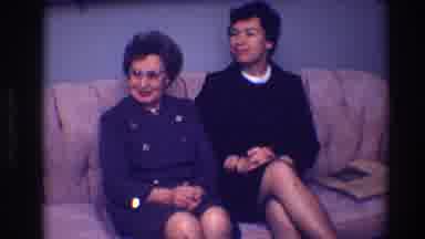 Toledo Ohio (1968): Two Women Sitting On A Brown Sofa In Short Dresses And Long