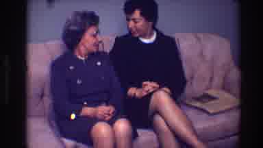 Toledo Ohio (1968): Two Women Sit On Tan Sofa In Blue Room Talking