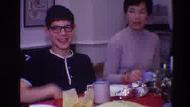 Toledo Ohio (1968): A Woman And Boy Sitting At A Dinner Table Smiling And Waving