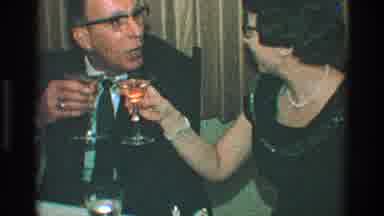 Toledo Ohio (1968): Two Adults In Formal Attire At Dinner Party Kiss While Holding