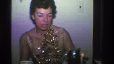 Toledo Ohio (1968): Lady In Sparkly Attire Sits Down At Table That Has A Small