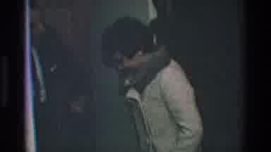 Toledo Ohio (1968): Man Helps A Woman In Coat Put On Her Shoes