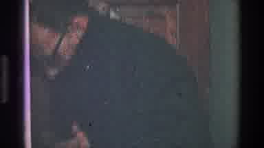 Toledo Ohio (1968): Man Fixing Black Suit And Handing Object To Another Person