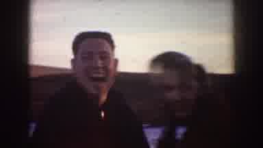 North Dakota (1953): Man Wearing Black Jacket Grabs Hand Of Woman Wearing Red Coat