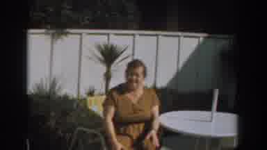 Los Angeles California (1961): Lady In Brown Dress Sitting In A Chair Next To A