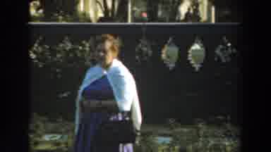 Los Angeles California (1961): Woman Wearing White Sweater Stands Near Gray Stone