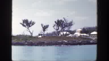 New York (1948): View Of Tan Buildings Brown Island And Blue Water On A Sunny Day