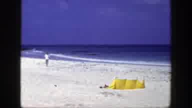 New York (1948): Two Persons Standing On The Beach Near The Sea And A Yellow Tent