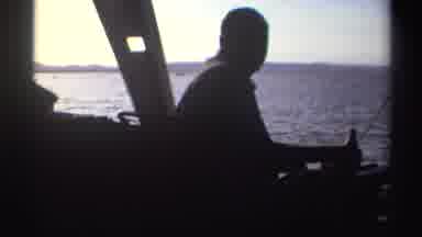 Nigeria (1969): Man Sitting On Boat And Drinking From Brown Bottle Looks Back And