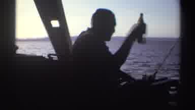 Nigeria (1969): Person From Brown Bottle While Group Of Men Weigh Fish On A Clear