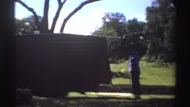 Nigeria (1969): Two People Setting Up Tent By Trees On A Sunny Day