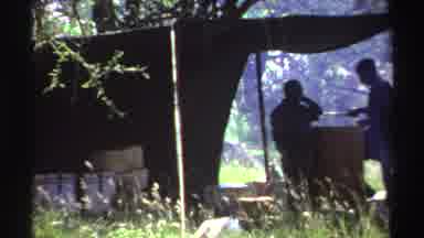 Nigeria (1969): Two Men Standing Underneath A Tarp Outside Followed By A Green