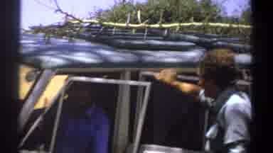 Kenya (1969): Man Wearing Grey Shirt Talks To Man Wearing Blue Shirt Sitting In