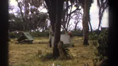 Kenya (1969): A Group Of Tents Have Been Set Up In A Campsite Surrounded By Trees