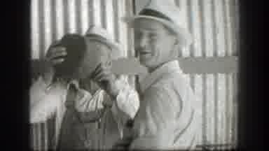 California (1939): Man Wearing Grey Hat Drinks From Jug On A Clear Day