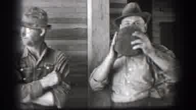 California (1939): Two Antique Trucks Travel Down A Dusty Road And Man Drinks From
