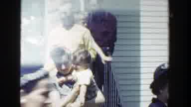 Wisconsin (1953): Woman Wearing Blue Dress Holds Hand Of Toddler Wearing Pink