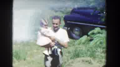 Wisconsin (1953): Woman With Child On Lap Man Walking With Child On Lap In Garden
