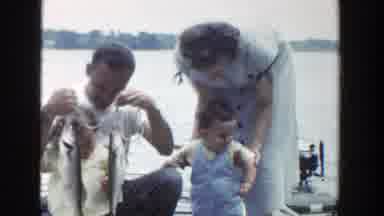 Wisconsin (1953): Man Wearing White Shirt Holds Two Fish While Woman Picks Up