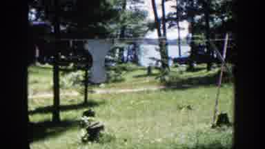 Wisconsin (1953): A Boy And A Girl Playing In A Small Pool In A Green Field With