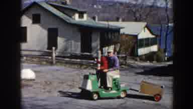 Pequot Lakes Minnesota (1964): Man And Child Driving Cargo Cart Around The Yard