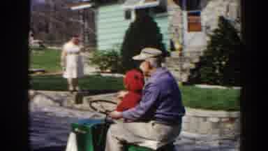 Pequot Lakes Minnesota (1964): An Elderly Man And A Boy Ride A Riding Lawn Mower