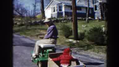 Pequot Lakes Minnesota (1964): Man Pulls Child In Wagon Down The Road With His