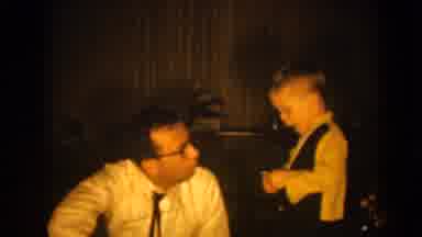 Pequot Lakes Minnesota (1964): Man Sitting Talking To Child In A Dark Room