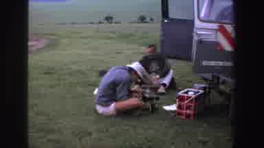 South Africa (1969): Man Walking On Grassy Spot Men Sitting On Floor Touching