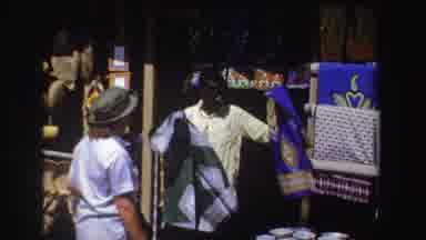 South Africa (1969): A Man In A Yellow Shirt Selling Blue Cloth With A Pattern To