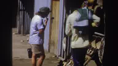 South Africa (1969): Person Wearing Green Hat Looks At Yellow Items At Outdoor