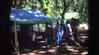 South Africa (1969): People Gathered Casually In A Wooded Area With Tents On A