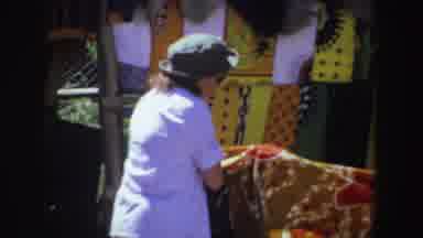 South Africa (1969): Person Wearing Green Hat Looking At Item From Outdoor Market