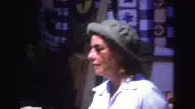 South Africa (1969): Woman Wearing Green Hat Helps Person Wearing White Hat Hold
