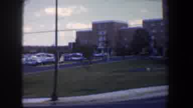 Baltimore Maryland (1960): View Of Tan Buildings And Light Blue Bus On A Clear Day