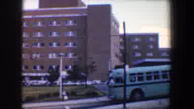 Baltimore Maryland (1960): A Brown Building With A Light Blue Green Bus Parked On