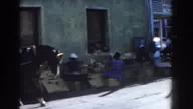 Nassau Bahamas-1961: Black Horse Pulls Cart Past Green Building On A Sunny Day