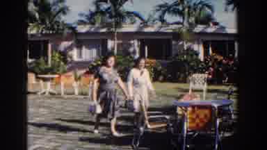 Nassau Bahamas (1961): Women Walking Towards Chairs Houses And Background Flowers