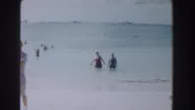 Nassau Bahamas (1961): Two People Wade Through The Water To The Shore As Others