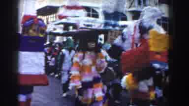 Nassau Bahamas (1961): Lots Of People Dress Up In Colour For Parade On The Road