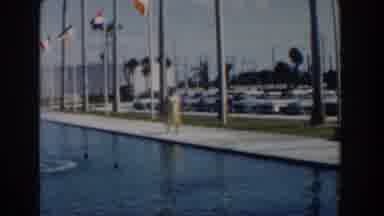 Nassau Bahamas (1961): Woman Wearing Yellow Dress Walks Past Blue Reflection Pool