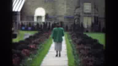 Cincinnatti Ohio (1949): Woman Wearing Green Jacket Walks Down Sidewalk On A Clear