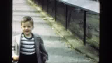 Cincinnatti Ohio (1949): A Kid Wearing A Coat Runs Past A Group Of Giraffes In A