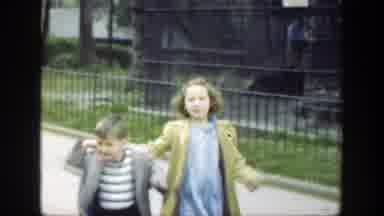 Cincinnatti Ohio (1949): A Girl And A Boy Running Side By Side At A Park With Some
