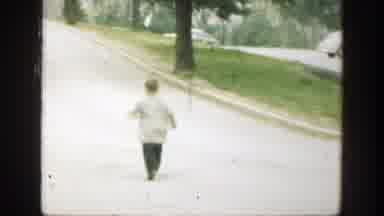 Cincinnatti Ohio (1949): Boy In A Long Gray Coat Runs Down A Paved Walkway And Is