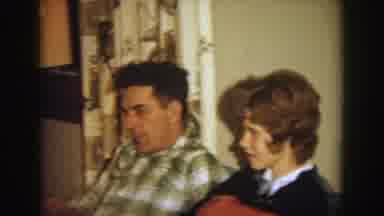 Wisconsin (1964): A Boy Smiles At The Camera With Men And Women Present