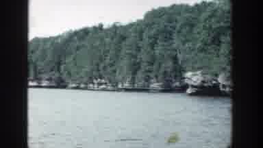 Wisconsin (1964): View Of Green Trees And Calm Blue Lake water On A Clear Day