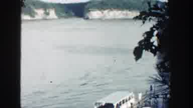 Wisconsin (1964): View Of A Body Of Water Followed By A Group Of People Walking